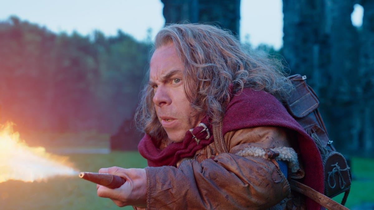 Warwick Davis holds a flamethrower in a scene from Willow