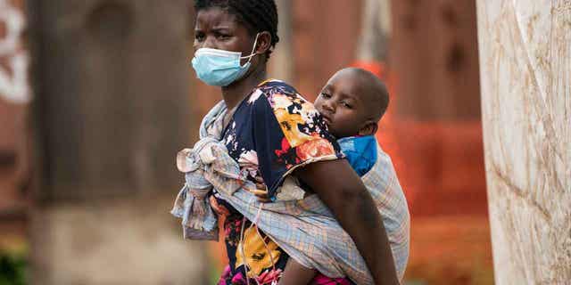 A child with cholera is carried by his mother in central Malawi, on Jan. 11, 2023. Malawi’s health minister says the country’s is suffering from the worst cholera outbreak in two decades. The lives of 750 people in Malawi have been claimed from Cholera since the outbreak began in March.  