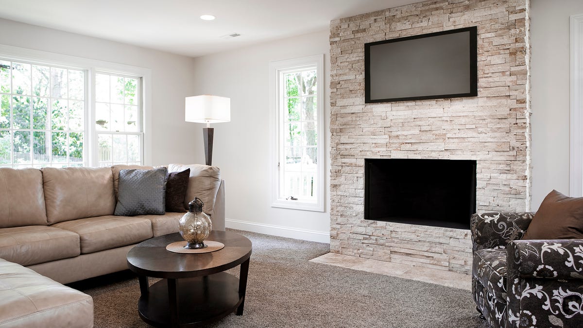 A TV mounted far too high and also above a fireplace.