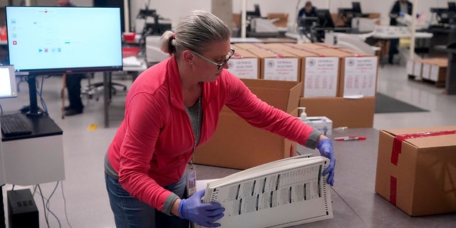 An election worker boxes tabulated ballots inside the Maricopa County Recorder's Office Nov. 9, 2022, in Phoenix.