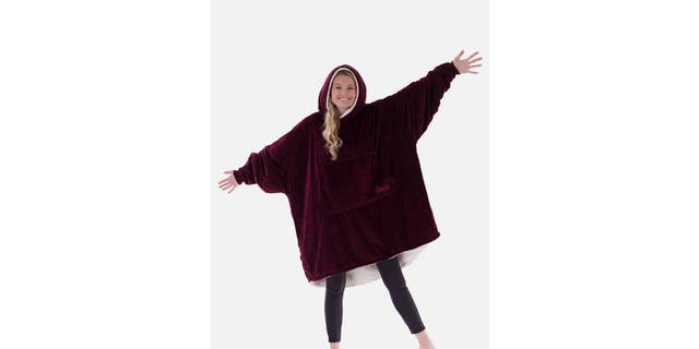A woman modeling The COMFY wearable blanket. 