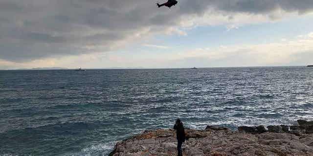 A helicopter searches for migrants over the Aegean Sea near the northwestern island of Lesbos, Greece, on Feb. 7, 2023. Three migrants died and 16 were rescued off the Greek island of Lesbos after their dinghy crashed into rocks.