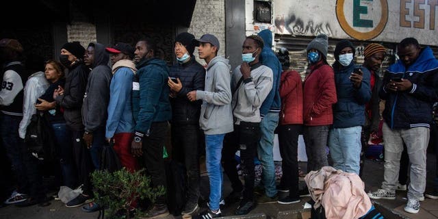 Migrants from Venezuela, Cuba, Haiti and Afghanistan wait in line outside at the Mexican Commission for Refugee Assistance in Mexico City Jan. 24, 2023. 
