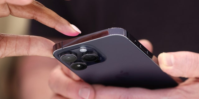  Attendees examine a brand new iPhone 14 Pro during an Apple special event on September 7, 2022, in Cupertino, California.