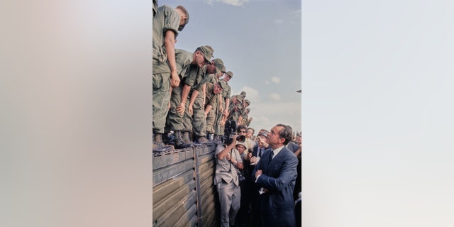 President Richard Nixon speaks with soldiers of the 1st Infantry Division at Di An Base Camp, South Vietnam, July 30, 1969.