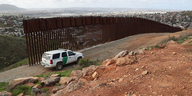 A U.S. Border Patrol vehicle stands at the U.S. and Mexico border fence near Tijuana, Mexico.