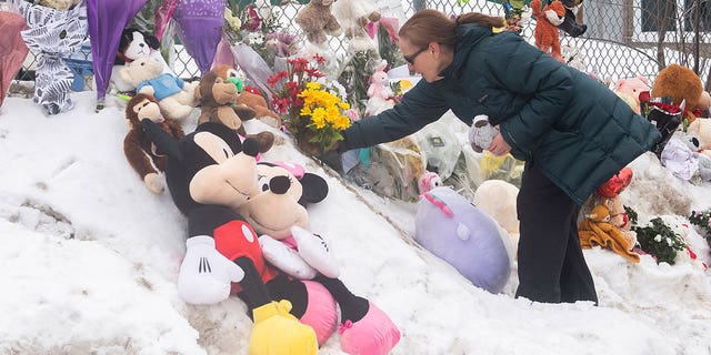 A woman mourns at the site of a bus crash into a Canadian daycare that killed two children.