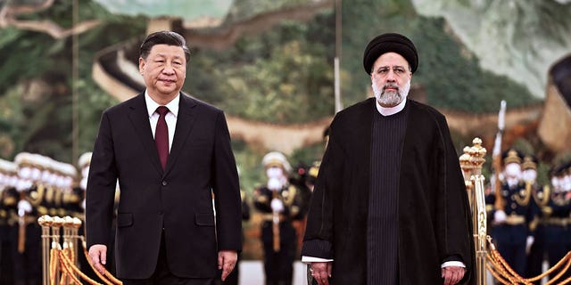 Visiting Iranian President Ebrahim Raisi, right, walks with Chinese President Xi Jinping during a welcome ceremony in Beijing, on Feb. 14, 2023. 