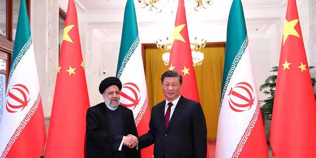 President Ebrahim Raisi, left, shakes hands with his Chinese leader Xi Jinping in an official welcoming ceremony in Beijing on Feb. 14, 2023. 