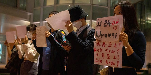 Protesters hold up white paper some with writings commemorating the Nov 24 deadly Urumqi fire during a gathering at the University of Hong Kong in Hong Kong, Tuesday, Nov. 29, 2022.