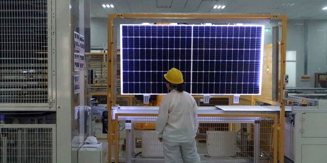 A worker quality checks a solar component in China. Imports from its Xinjiang region have been suspended over concerns of slave labor.