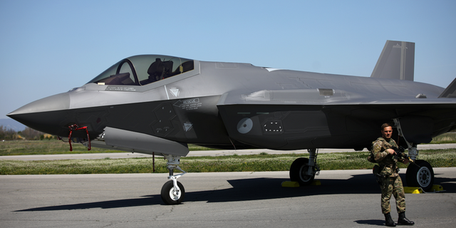 A Dutch soldier stands guard near a Royal Netherlands Air Force F-35 at Graf Ignatievo airbas in Bulgaria on April 14, 2022.