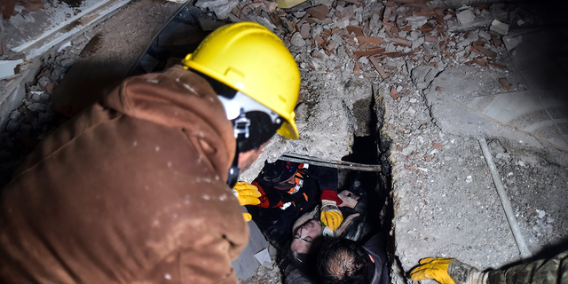 Emergency workers and medics rescue a woman out of the debris of a collapsed building in Elbistan, Kahramanmaras, in southern Turkey, Tuesday, Feb. 7, 2023.