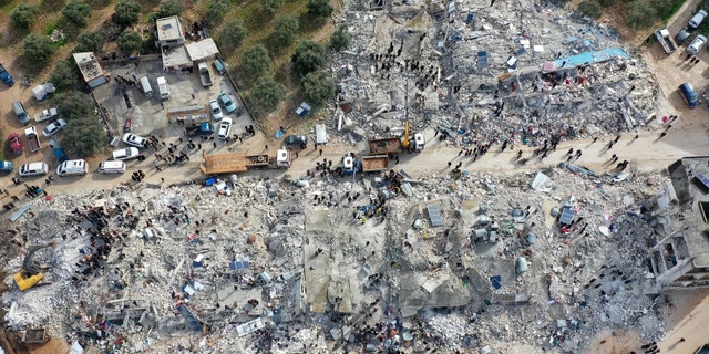 This aerial view shows residents searching for victims and survivors amidst the rubble of collapsed buildings following an earthquake in the village of Besnia near the town of Harim, in Syria's rebel-held northwestern Idlib province on the border with Turkey, on Feb. 6, 2022. 