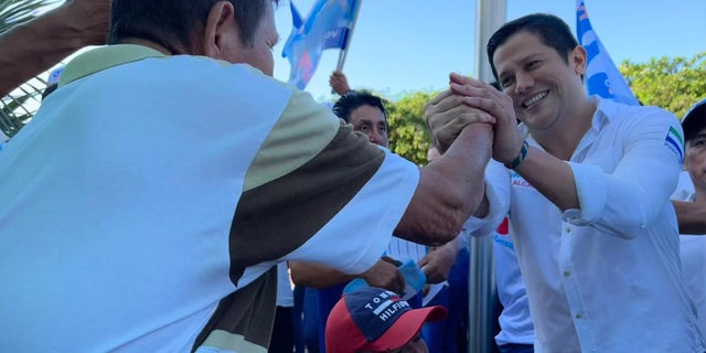 Mayoral candidate Omar Menéndez, right, with supporters in Ecuador wins election following his murder.