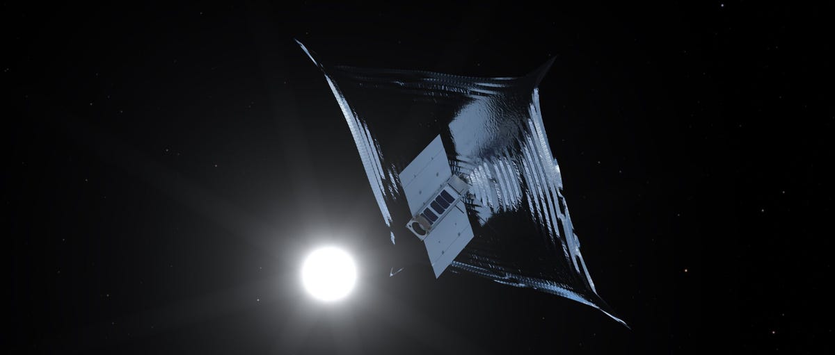 A silver space sail is seen with a gleaming star in the background.