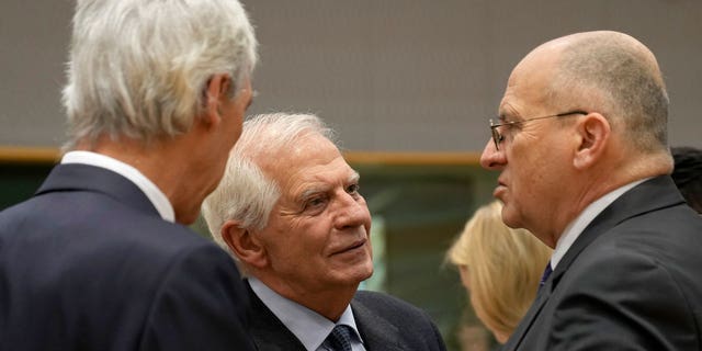 European Union foreign policy chief Josep Borrell, center, speaks with Poland's Foreign Minister Zbigniew Rau, right, and Portugal's Foreign Minister Joao Gomes Cravinho, left, during a meeting of EU foreign ministers at the European Council building in Brussels on Feb. 20, 2023.