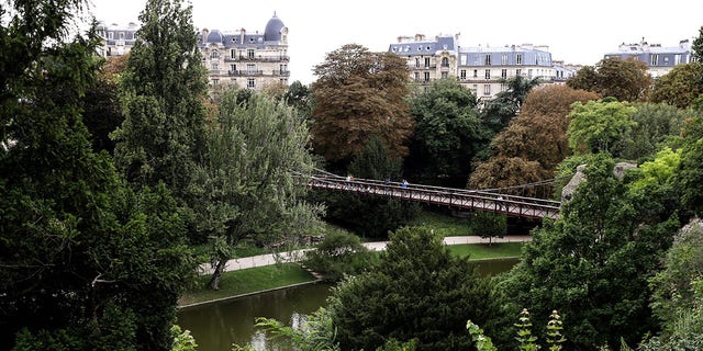 FILE: People walk on a suspended bridge designed by French engineer Gustave Eiffel in the Buttes-Chaumont Park in Paris. 