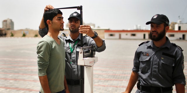 An applicant is measured at a Hamas recruitment center in Gaza City on June 3, 2013. (Reuters/Mohammed Salem)
