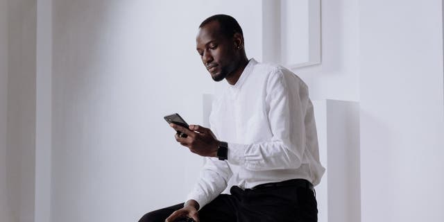 Image of a man using his iPhone. 