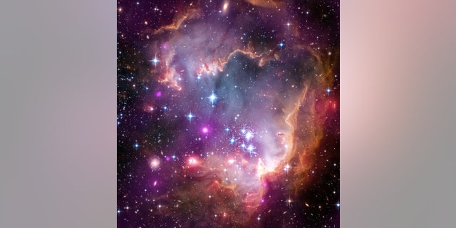 The tip of the "wing" of the Small Magellanic Cloud galaxy is dazzling in this 2013 view from NASA's Great Observatories. The Small Magellanic Cloud, or SMC, is a small galaxy about 200,000 light-years way that orbits the Milky Way spiral galaxy.