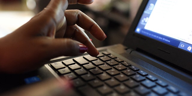 A woman uses a laptop on April 3, 2019, in Abidjan. - According to the figures of the platform of the fight against cybercrime (PLCC) of the national police, nearly one hundred crooks of the internet, were arrested in 2018 in Ivory Coast, a country known for its scammers on the web, has announced on April 2, 2019 the Ivorian authority of regulation of the telephony. 
