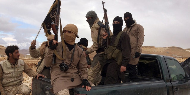 Al-Qaeda-linked Nusra Front fighters carry their weapons on the back of a pick-up truck during the release of Lebanese soldiers and policemen in Arsal, eastern Bekaa Valley, Lebanon, December 1, 2015. 