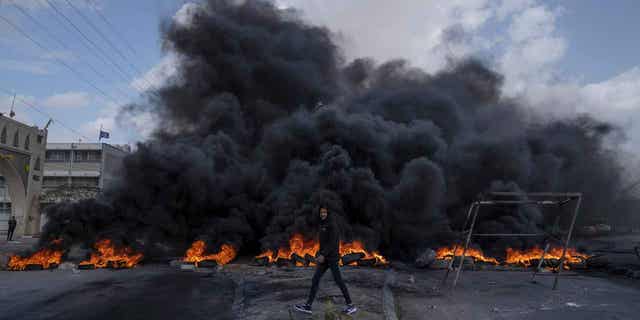 Palestinian protesters block a road with burning tires in the West Bank on Feb. 6, 2023. Israeli forces killed five Palestinian gunmen in a raid in the occupied West Bank on Monday.