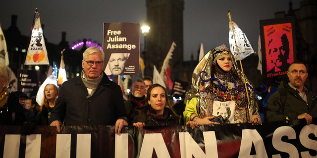 Supporters of Julian Assange walk during a 'Night Carnival for Assange' march in London.