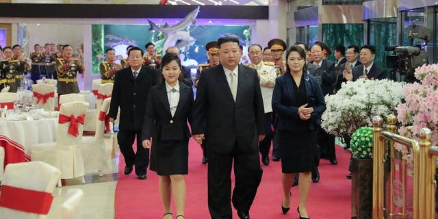 Kim Jong Un, with his wife Ri Sol Ju, right, and his daughter Ju-ae attend a feast to mark the 75th founding anniversary of the Korean People’s Army at an unspecified place in North Korea on Tuesday, Feb. 7, 2023.