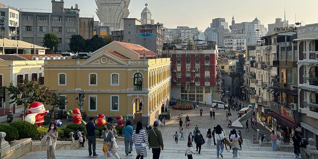 Tourists walk at a historic site in Macao on Dec. 28, 2022. Starting Feb. 27, 2023, people no longer have to wear masks when outdoors. 