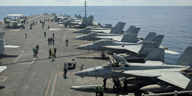 This photograph taken Oct. 16, 2019, shows U.S. Navy F/A-18 Super Hornets multirole fighters and an EA-18G Growler electronic warfare aircraft, second right, on board the USS Ronald Reagan (CVN-76) aircraft carrier as it sails in the South China Sea on its way to Singapore. 