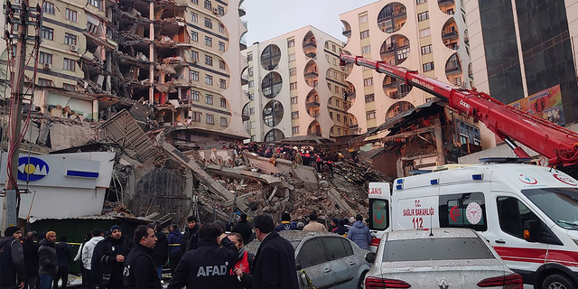 Rescue workers and medical teams try to reach trapped residents in a collapsed building following an earthquake in Diyarbakir, southeastern Turkey.