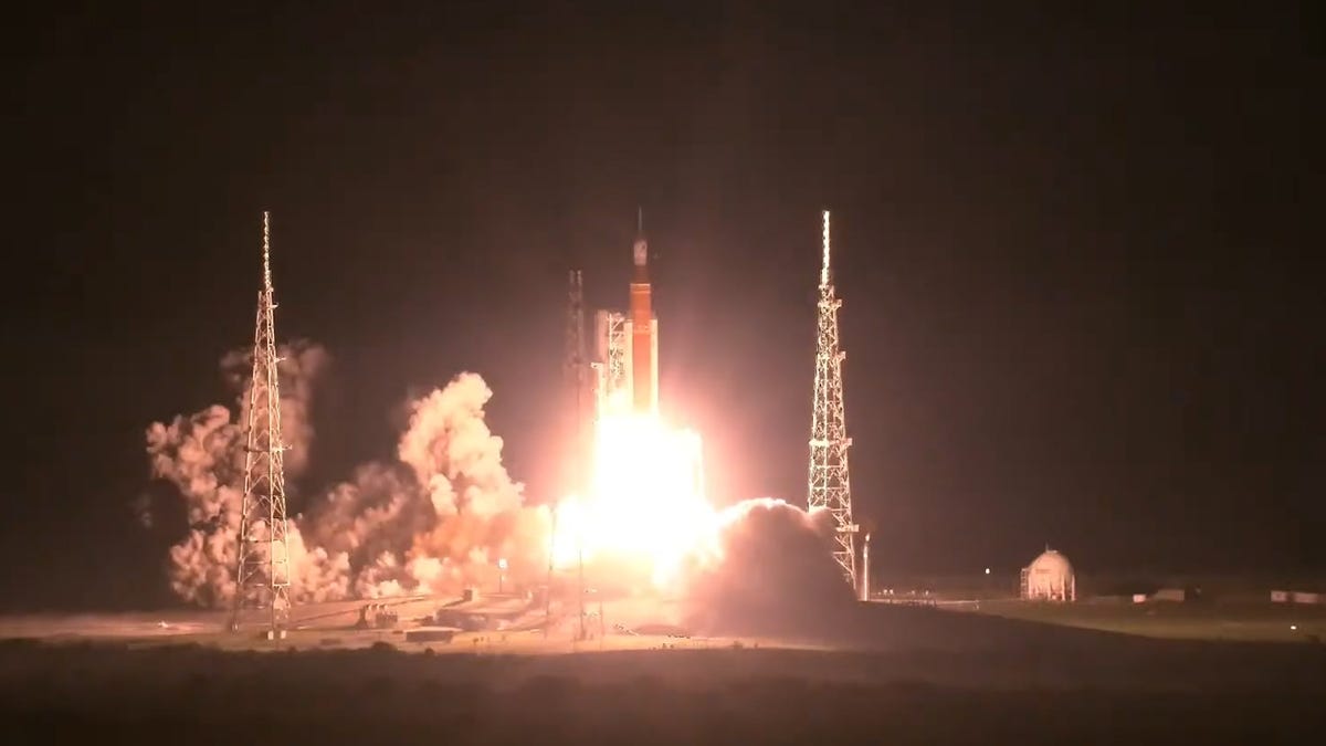 Artemis I rocket lifts off, flashing bright against a night sky