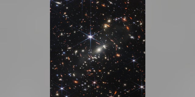 The first released Monday from the James Webb Space Telescope shows galaxies around each other whose light has been bent, NASA officials said. 