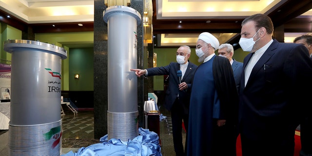 Former President Hassan Rouhani, second right, listens to head of the Atomic Energy Organization of Iran Ali Akbar Salehi while visiting an exhibition of Iran's new nuclear achievements in Tehran, Iran, in April 2021.