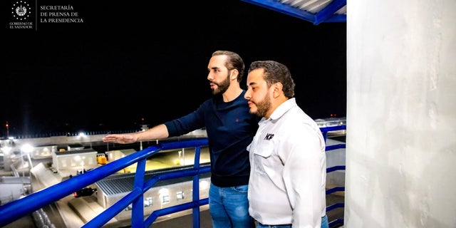 President Nayib Bukele stands in an observation tower with the Minister of Public Works Romeo Rodriguez during a national television transmission to present the Terrorism Confinement Center on Feb. 1, 2023.