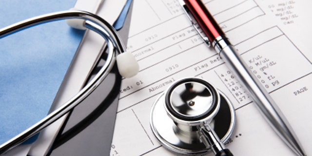 A picture of a stethoscope and pen resting on a sheet of medical lab test results.