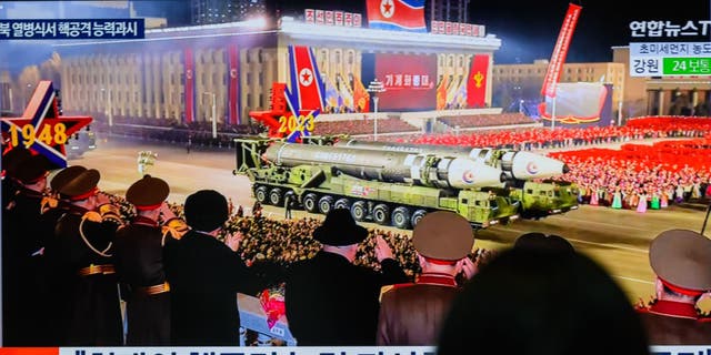 A pair of ICBM launchers pass by crowds in Pyongyang. 