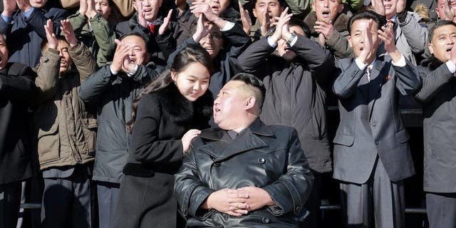 This undated photo provided on Nov. 27, 2022, by the North Korean government shows North Korean leader Kim Jong Un, center right, with his daughter, center left, pose with scientists and workers for a photo, following the launch of what it says a Hwasong-17 intercontinental ballistic missile, at an unidentified location in North Korea. 