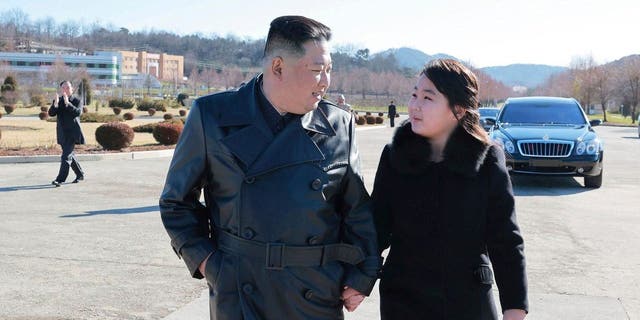 North Korean leader Kim Jong Un, left, and his daughter, right, walk to a photo session with those involved in the recent launch of what it says a Hwasong-17 intercontinental ballistic missile, at an unidentified location in North Korea. 