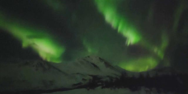 The green lights shimmered over Anchorage terrain and communities. 