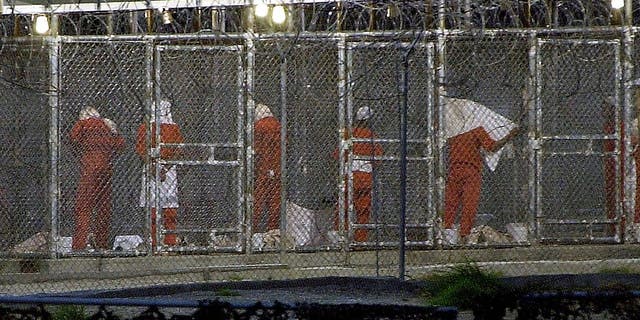 Detainees prepare themselves for the evening prayer March 4, 2002, at Camp X-Ray in Guantánamo Bay, Cuba by facing towards Mecca.  Some 300 detainees from Afghanistan are being held at the US Naval Base in Guantánamo Bay, Cuba. 