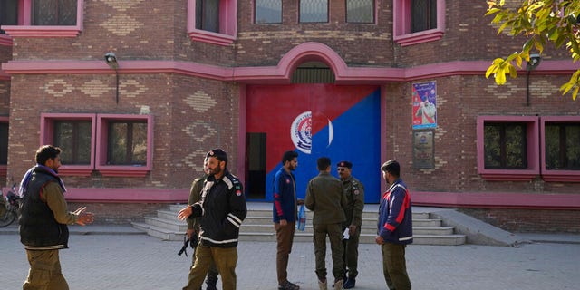 Police officers gather outside a police station, in Warburton, an area of district Nankana, Pakistan, Sunday, Feb. 12, 2023.