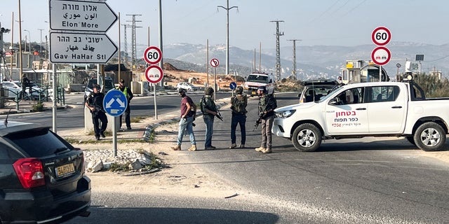 Israeli security personnel stand as they guard a main junction, close to where Israeli police said two Israelis were killed, near Nablus, February 26, 2023. 