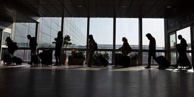 Travelers walk with their luggage in the Ben Gurion Airport near Tel Aviv, Israel, on Nov. 28, 2021. 