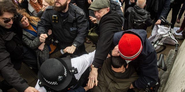 Police struggle to keep the two sides apart as anti drag queen protestors are pushed off the steps of Tate Britain on Feb. 11, 2023 in London.