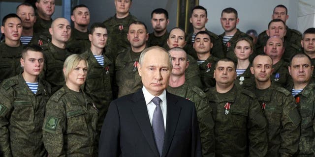 President Vladimir Putin, center, speaks in his annual televised New Year's message after a ceremony during a visit to the headquarters of the Southern Military District, at an unknown location in Russia, on Saturday, Dec. 31, 2022.