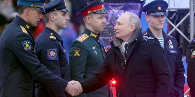 Russian President Vladimir Putin greets members of the military during a concert in Luzhniki Stadium on Feb. 22, 2023, in Moscow.