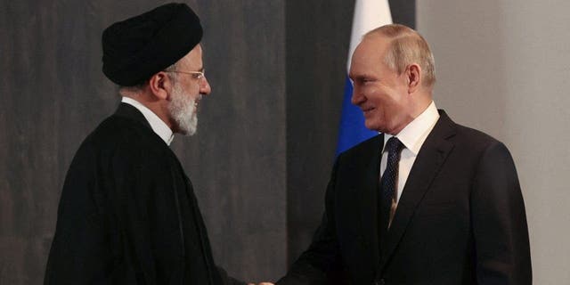 Russian President Vladimir Putin shakes hands with Iranian President Ebrahim Raisi during the Shanghai Cooperation Organization summit in Samarkand, Uzbekistan, on Sept. 15, 2022.